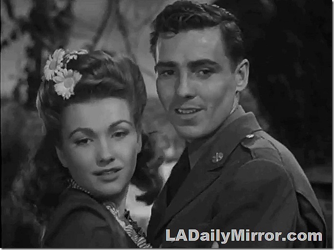 Mystery couple. Woman has flowers in her hair and the man is in uniform. 